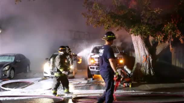자동차에서 화재를 일으키는 호스와 일하는 소방대원들 — 비디오