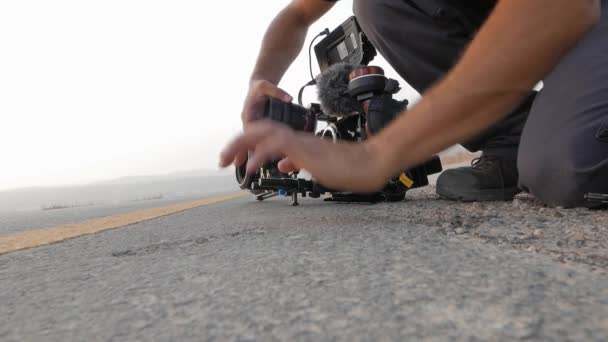 Professioneller Videofilmer Justiert Ausrüstung Und Kamera Auf Der Asphaltstraße — Stockvideo