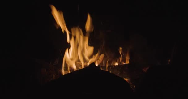 Önünde Kayaların Silueti Olan Sıcak Bir Kamp Ateşi Gece Parlıyor — Stok video