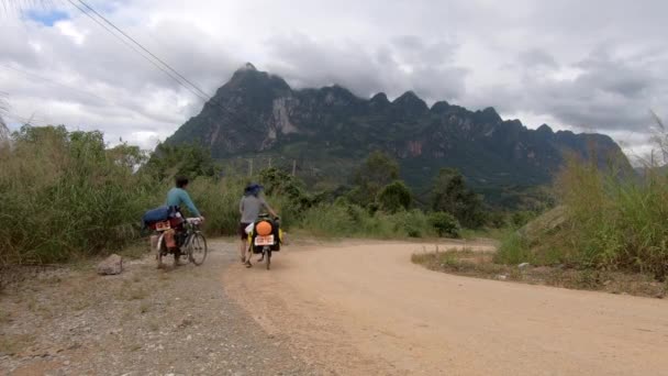 Dos Jóvenes Vietnamitas Adultos Caminando Con Sus Bicicletas Camino Tierra — Vídeo de stock