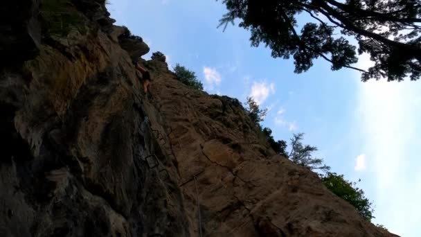 一个穿着热裤的女孩爬上岩石的镜头 — 图库视频影像
