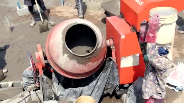 西アフリカのナイジェリアでの建設プロジェクトでは 労働者がバケツを頭に担いでセメントを混合する — ストック動画