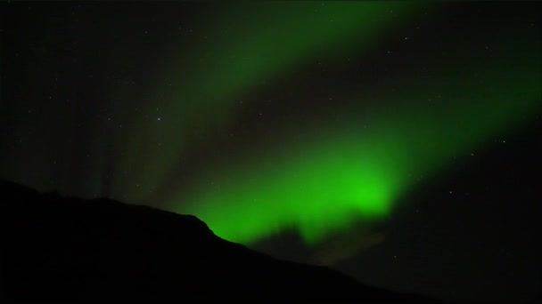 在冰岛的高山与火山之间的漆黑夜晚 拍摄的绿色北极光和夜空中的星星 — 图库视频影像