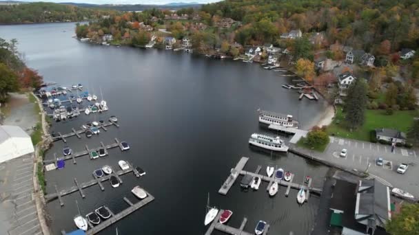 ニューハンプシャー州のサナピー レイクフロント ドック ボート 湖畔の家やカラフルな秋の紅葉 ドローンショットの空中ビュー — ストック動画
