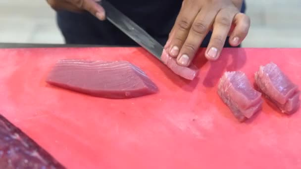 日本のおまかせ料理長は 寿司を作るために木製のキッチンカウンターでナイフできれいにクロマグロを切りました — ストック動画