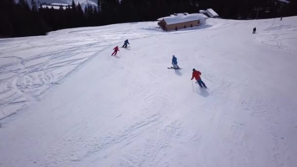 从空中俯瞰滑雪场 人们乘着滑雪板下山 库存录像 在雪地上滑过雪地或雪地 被茂密的森林环绕 旅行和运动 — 图库视频影像