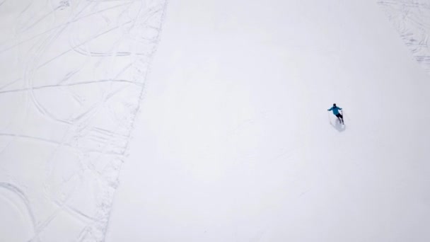 松林と太陽の山のスキーリゾートの空中 リフトで雪の斜面を滑り降りる 冬の自然景観 男性と女性の極端なスポーツ 積極的かつ健康的なライフスタイル 雪のトウヒの木 — ストック動画