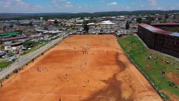 Lassú mozgó drón mutatja Afrika Gyerekek fociznak egy nagy pályán gyönyörű kék ég.