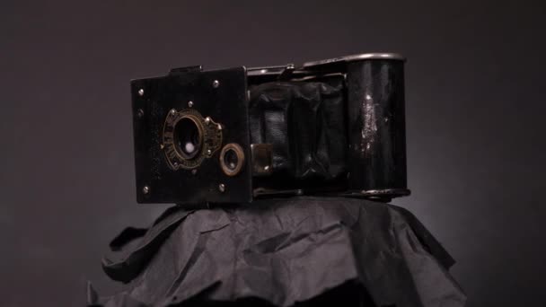 Ročník Camera rotující v černém pozadí - Vest Pocket Kodak Camera. - detailní