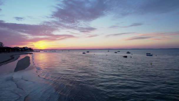 カラフルな夕日の間に空中のフライオーバー海岸 港に係留スピードボート — ストック動画