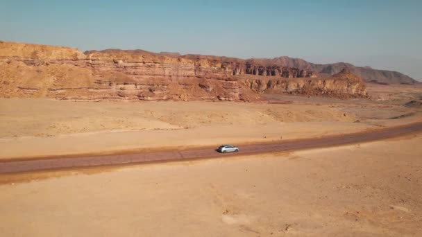 砂漠の道を走る車の次のドローンショット砂漠のシーンへの遷移のための素晴らしいショット — ストック動画