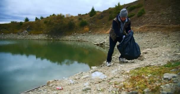 Eco Ativista Homem Coletando Lixo Lixo Margem Lago Homem Voluntário — Vídeo de Stock