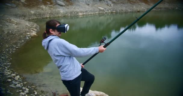 Νεαρό Ενθουσιασμένο Αρσενικό Ψαρεύει Στη Λίμνη Του Βουνού Φορώντας Γυαλιά — Αρχείο Βίντεο