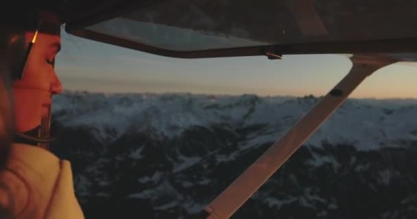 Mujer Dentro Avión Mirando Atardecer Detrás Alpinos Nevados Suiza — Vídeo de stock