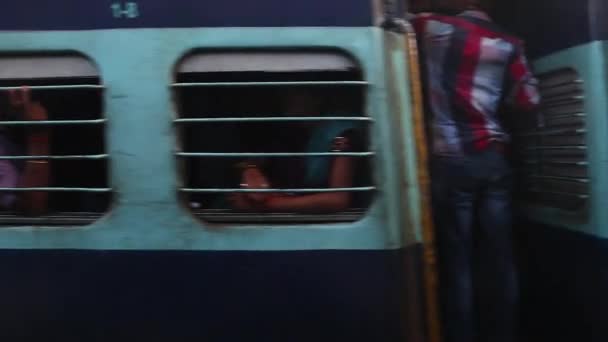 拥挤的火车从印度火车站开出 人们坐在车厢里向窗外望去 — 图库视频影像