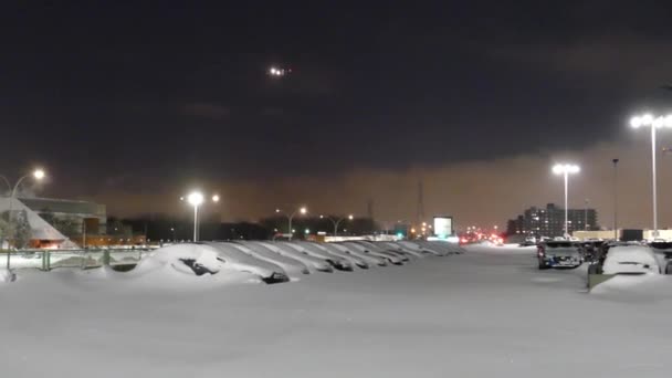 空港駐車場だけで寒い雪の夜 冬の夜に飛行機が飛ぶ — ストック動画