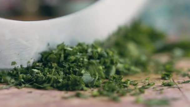 一个非常接近的女人的手快速切绿色欧芹对着相机用一把意大利锋利的刀在她厨房的木板上 家庭烹饪和健康食品概念 — 图库视频影像