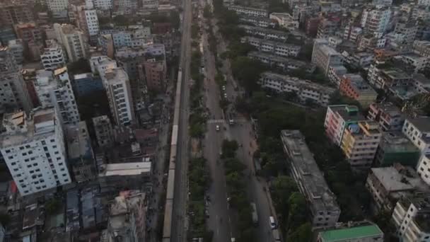 ドローン飛行は バングラデシュのダッカ市内の高速道路に沿って列車や交通の流れを示しています — ストック動画