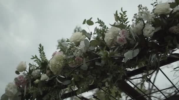 Svatební květinová výzdoba s bílými a růžovými květy a zelenými listy na louce