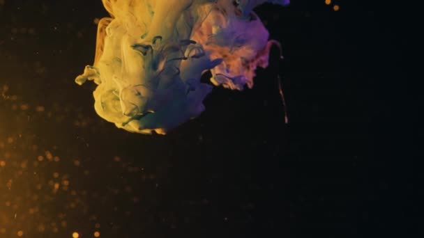 宏观慢镜头 墨水的云彩隔绝了 彩色抽象烟雾爆炸镜头 五颜六色的黄色 白色和蓝色的油漆从水面上滴落 轻轻荡漾在水下 — 图库视频影像