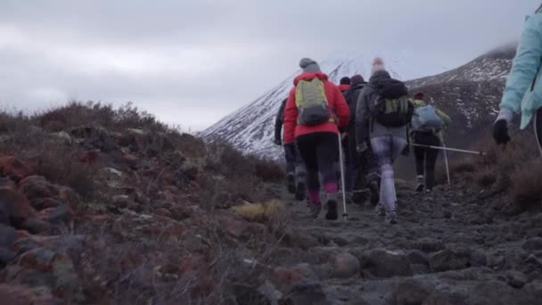 Túrázók mennek fel a Tongariro-hegyre télen, felhős napokon, csoportos kirándulás