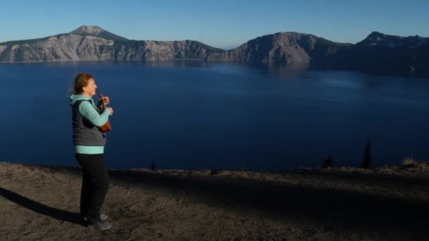 Žena Důchodu Hraje Ukulele Zároveň Obdivuje Národní Park Crater Lake — Stock video