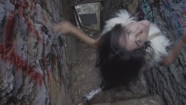 放棄された動物園の階段で彼女を撃墜高角度にまっすぐ見つめて回る奇妙な解釈ダンサーのスローモーションショット — ストック動画