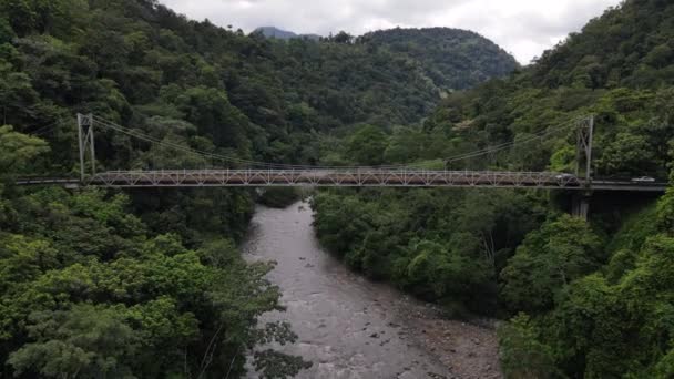 Puente Peas Blancasの4K映画空撮 コスタリカのジャングルの真ん中にある古い鉄橋 無人機がゆっくりと上昇している間にいくつかの車は 古代の構造を横断 — ストック動画