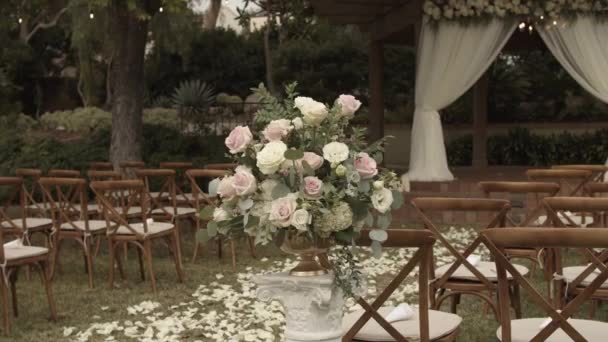 Přípravy na svatební obřad. Pohled na květinovou výzdobu, oltář v pozadí, prostor k posezení a stezku lemovanou okvětními lístky
