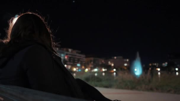 女の子は椅子に座って モンペリエのポート マリアンヌで夜の噴水を見ています フランス 閉じるショット — ストック動画