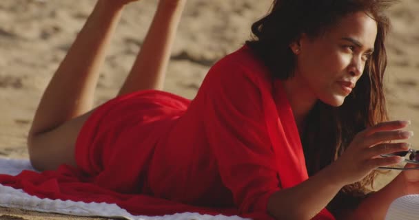 Mulher Latina Deitada Sua Frente Sandy Beach Olha Para Câmera — Vídeo de Stock