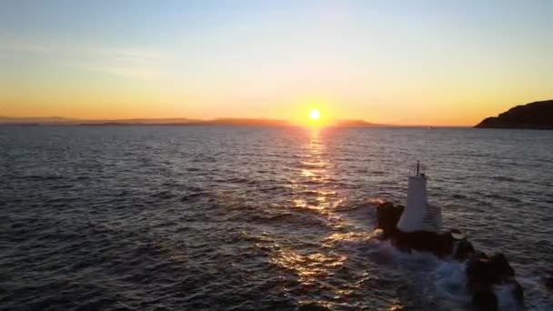 波が小さな灯台を襲ったときの海の夕日 — ストック動画