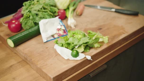Mann Wirft Salatblätter Und Plastikfolie Biotonne — Stockvideo