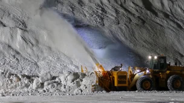 スローモーション道路から巨大な雪の山への雪を吹く大雪 夜に働くスノーブロワー — ストック動画