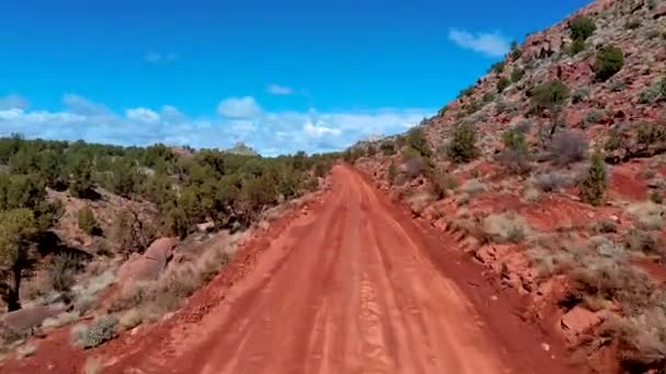 旅行はほこりだらけの赤い農村部の道路の空中ビューを撃墜した ドローンショットオブワイヤーパス 朱色の崖 ユタ州 — ストック動画