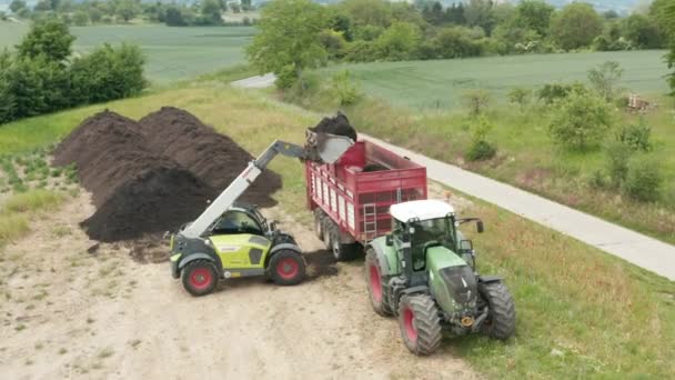 Drohnenschuss Eines Radladers Der Kompost Auf Den Anhänger Eines Traktors — Stockvideo