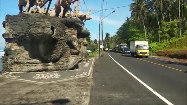 高速道路を通過する車両の映像です 2021年11月2日バリ島JembanaのYeh Leh Beach地域に位置するMakepung牛像 — ストック動画