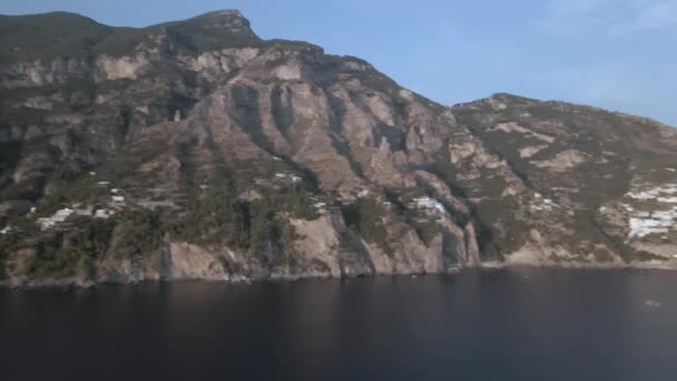 アマルフィ海岸ポジターノイタリア急峻な山の崖から水の上のメガヨットにパンニングドローン映像 — ストック動画
