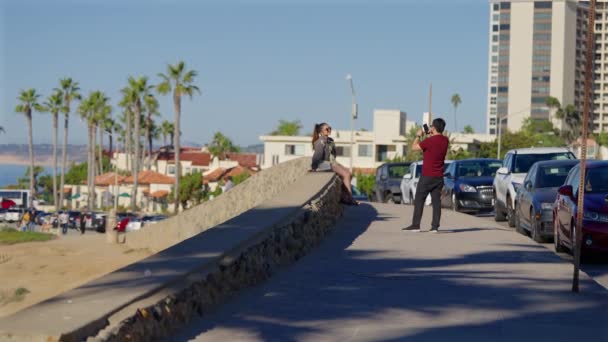 カリフォルニア州ラホヤの橋の上に立つ少女の写真を撮る男 4分の1速度に減速 — ストック動画