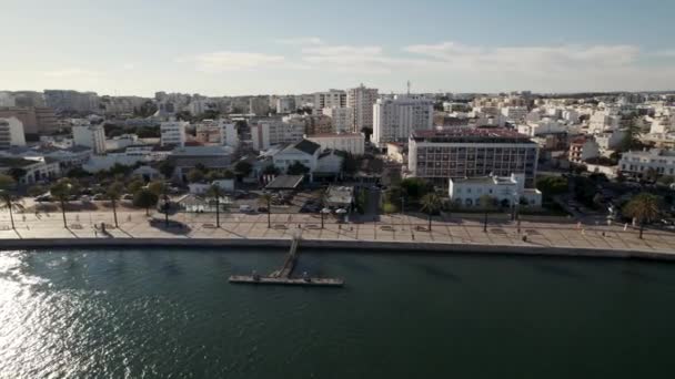 アルガルヴェ アルガルヴェ市内の建物Arade川に反射する太陽 ポルティモ遊歩道上の航空軌道 — ストック動画