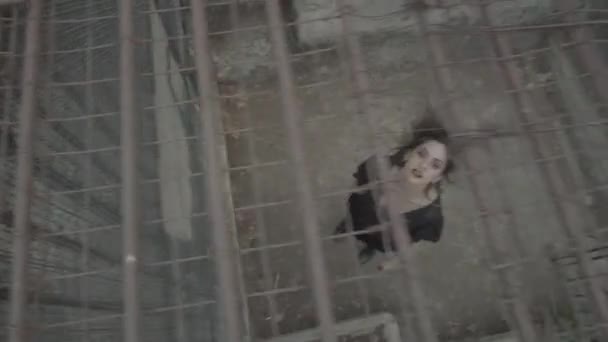 Gothic Girl Black Clothes Scary Smile Stretches Her Arms Cage — Stock Video