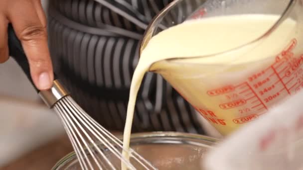 将牛奶和黄油加入搅拌鸡蛋中 混合华夫饼面团或面团面团的湿配料 — 图库视频影像