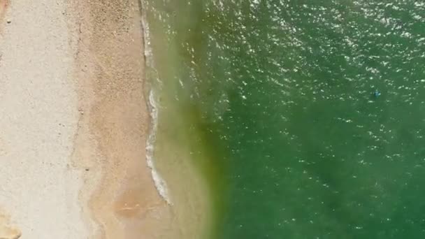 ギリシャのケファロニア島のエルサレムビーチ エメラルドグリーンの水と小さな泡の波が砂の海岸に転がり素晴らしいビーチ トップダウンビュー ドローンショット — ストック動画