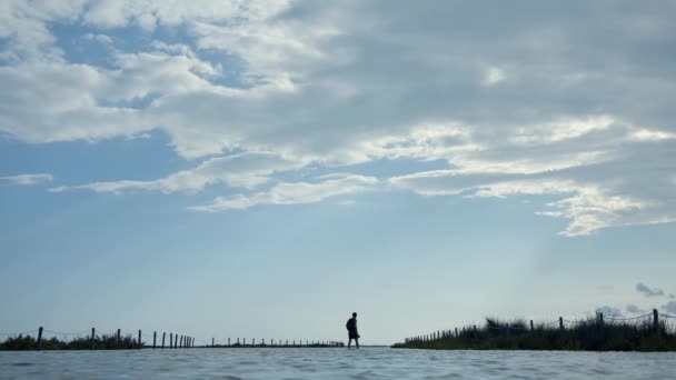 Szerokie Ujęcie Mężczyzn Spacerujących Zalanym Obszarze Plaży — Wideo stockowe