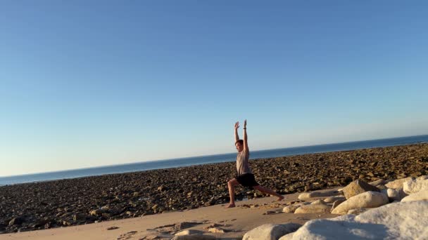 Young Guy Macht Yoga Moves Vor Dem Atlantik Leeren Strand — Stockvideo