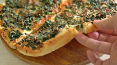 Tahta tepside ıspanaklı ve peynirli pizza. Vejetaryen ve vejetaryen yemek tarzı.