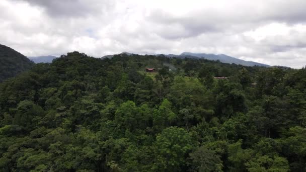 在中美洲 无人机绕着一座被茂密的热带雨林覆盖的山和一座山顶建筑飞行 秃鹰飞过去了哥斯达黎加真实生活理念的电影4K航拍 — 图库视频影像