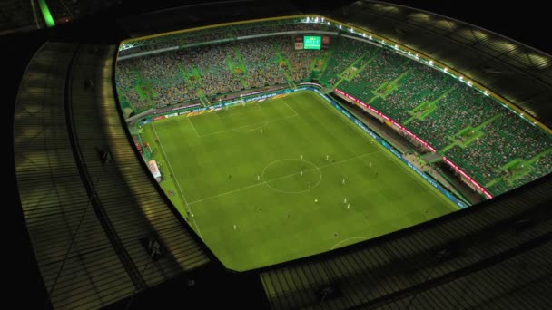 人们在有夜灯的体育场内踢足球的空中景象 — 图库视频影像