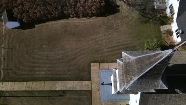 4K人离开艾伯塔省农村一个古老的木制草原教堂的空中录像 年轻人走在狭窄的小径上 走出了框框 无人机以45度的角度拍摄场景缓慢上升 — 图库视频影像