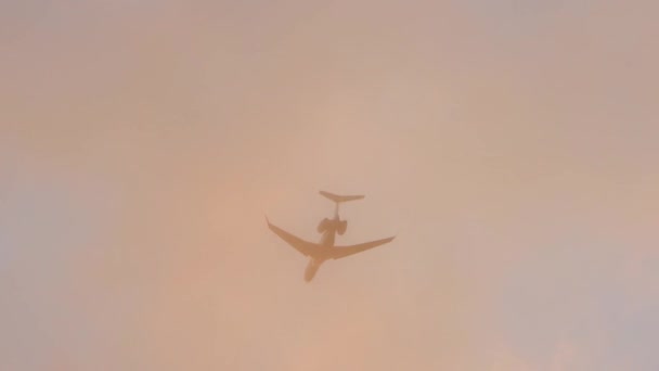 黄金の時間の間にカラフルな雲を通過する飛行機を示す地上からの眺め 翼蒸気結露雲 — ストック動画